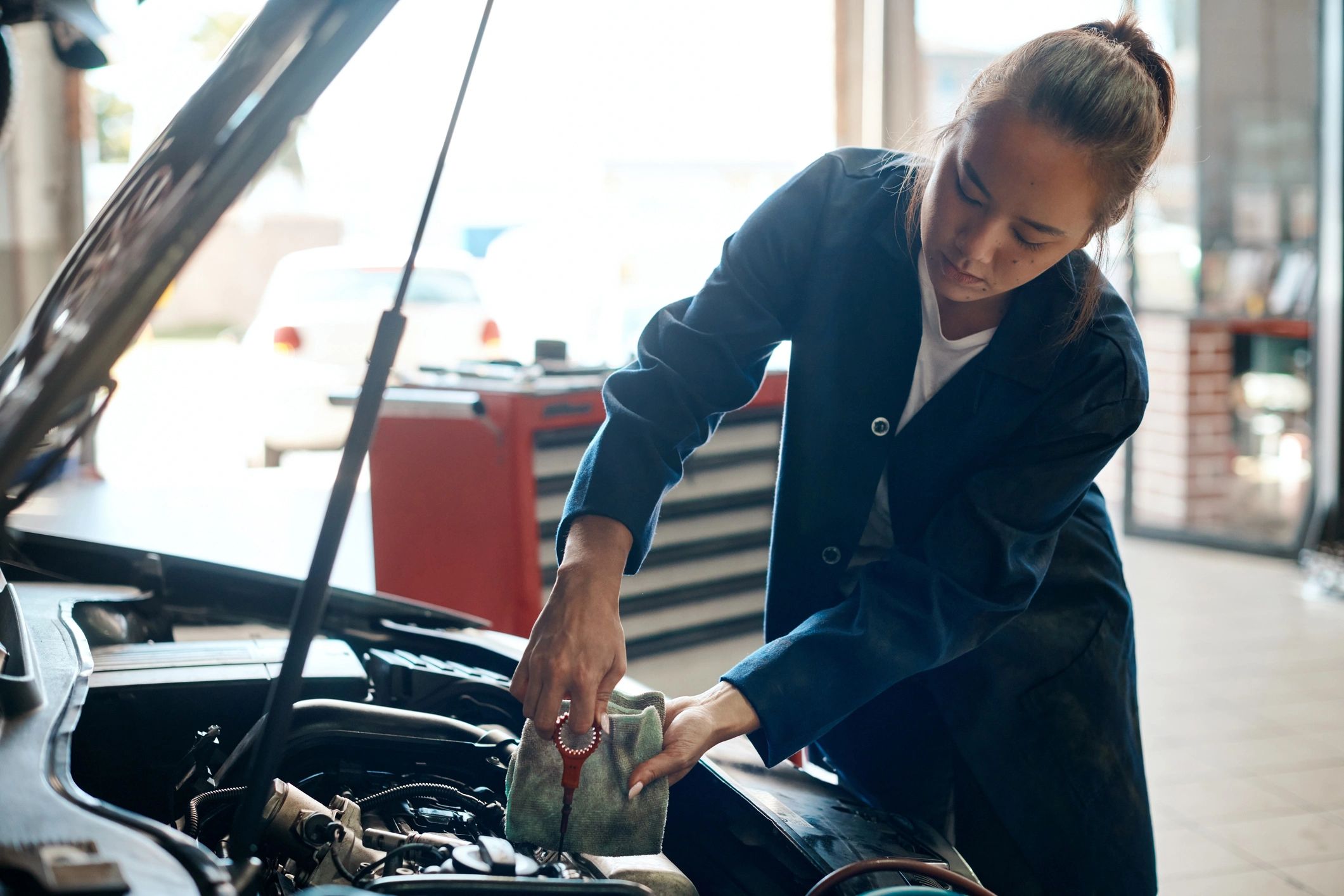 Mechanic checking a car's oil level with dipstick