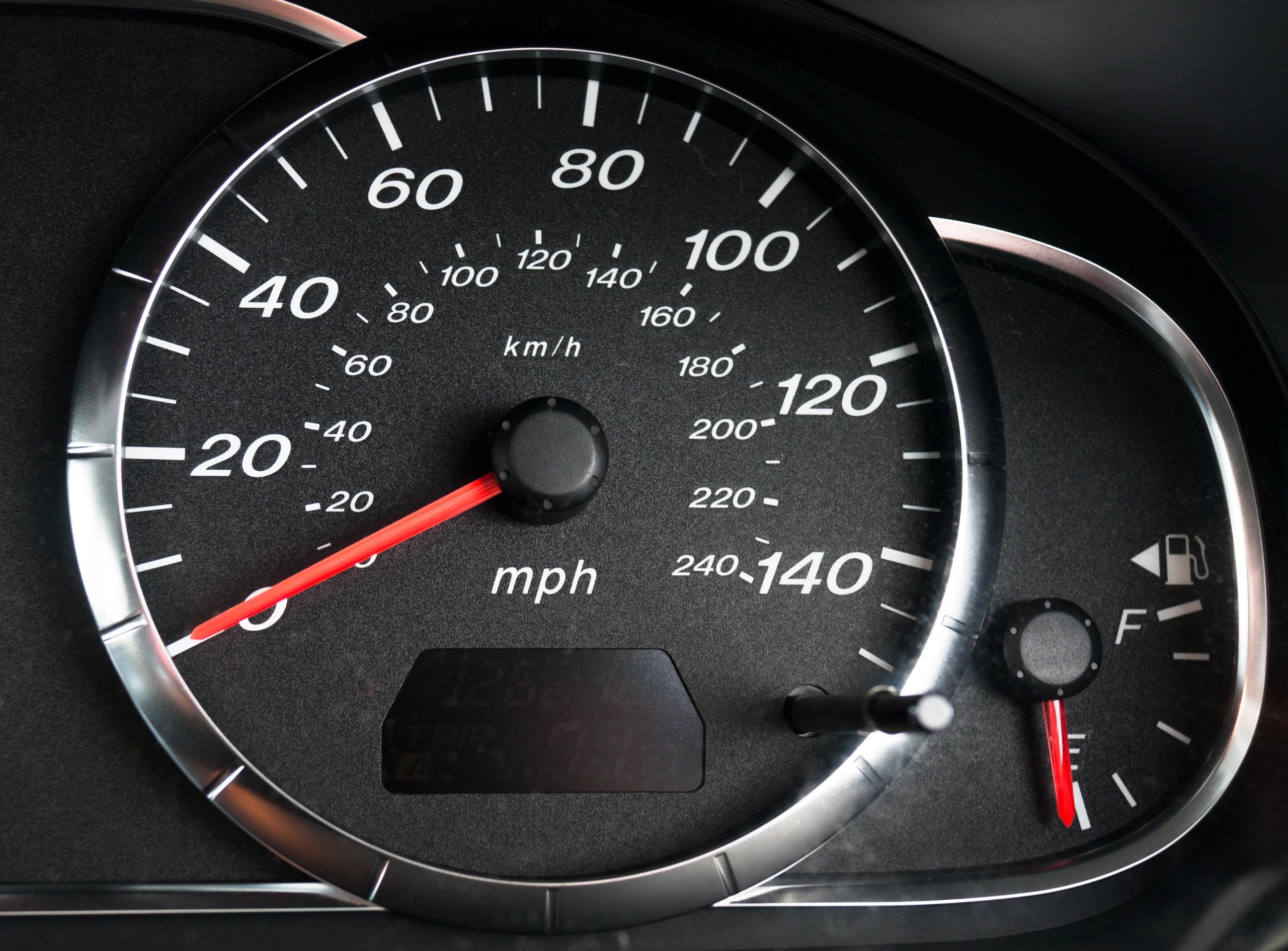 Car dashboard close-up with gauges and warning indicators