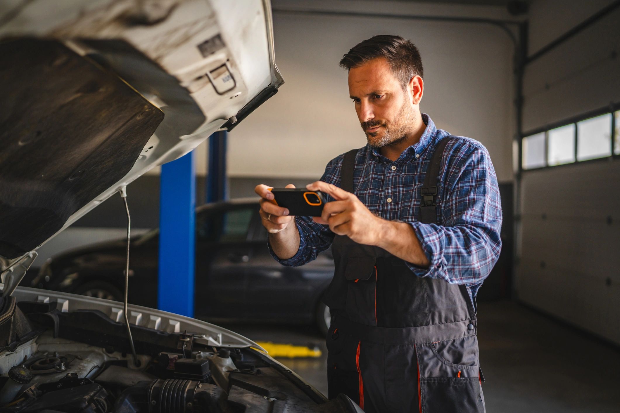 Technician performing modern vehicle diagnostics in the shop