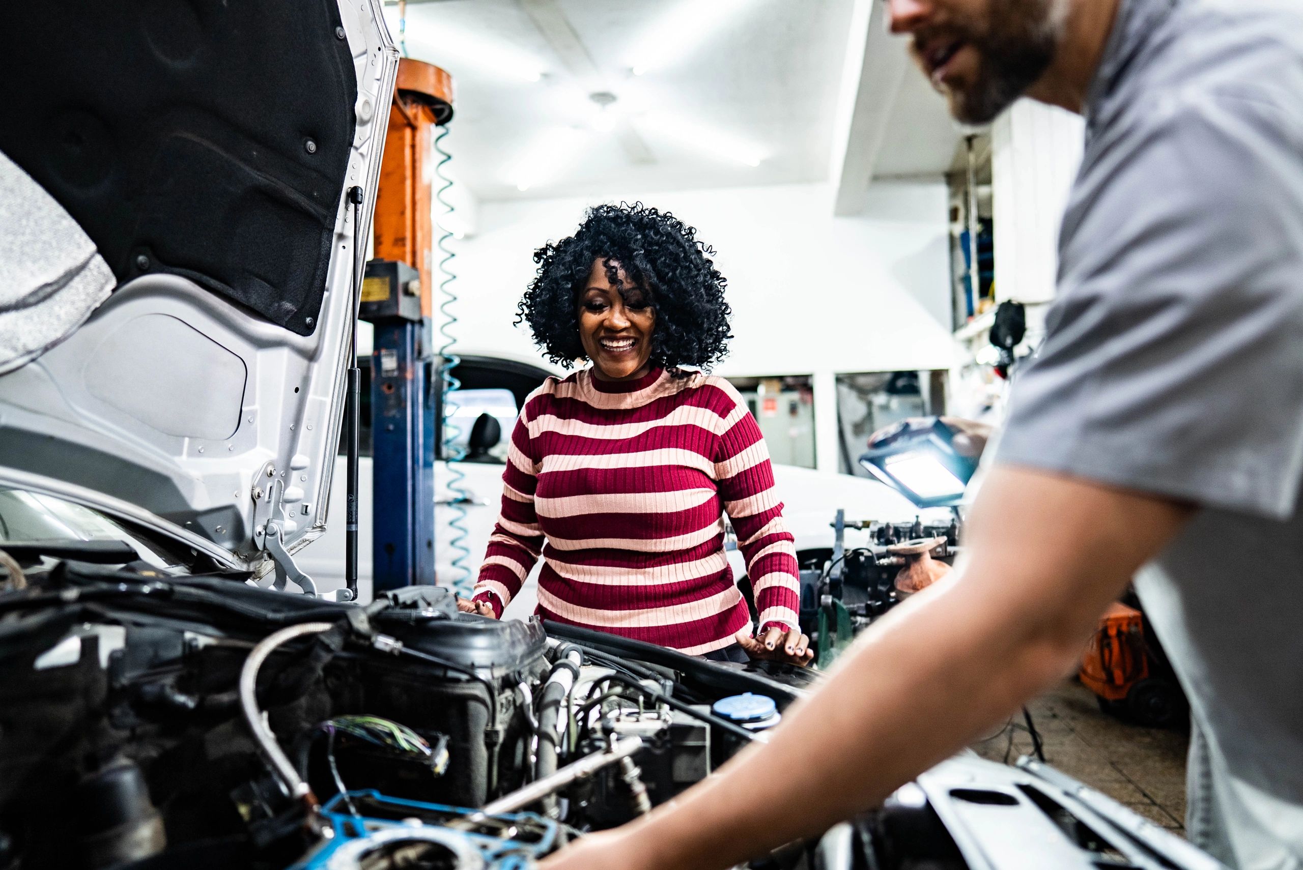 Customer speaking with a mechanic at a repair shop